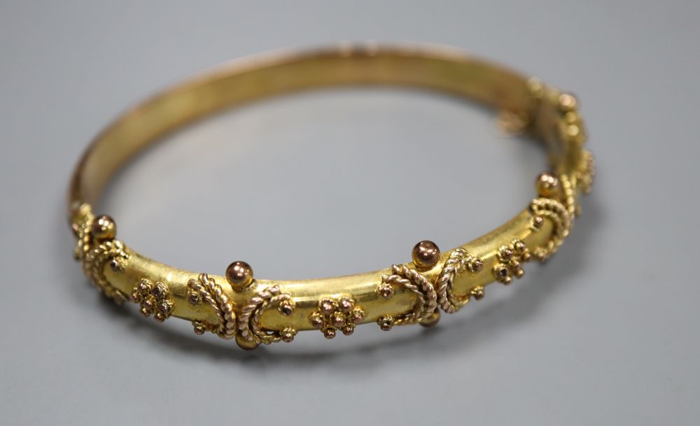 A late Victorian 9ct gold hinged bangle, gross 9.1 grams, with engraved initials.